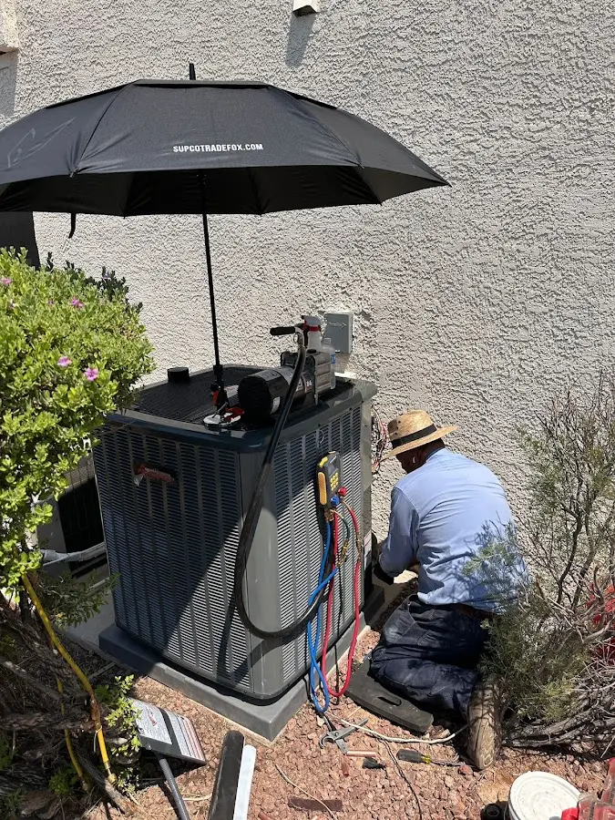 HVAC technician performing outdoor AC maintenance in Kenmore