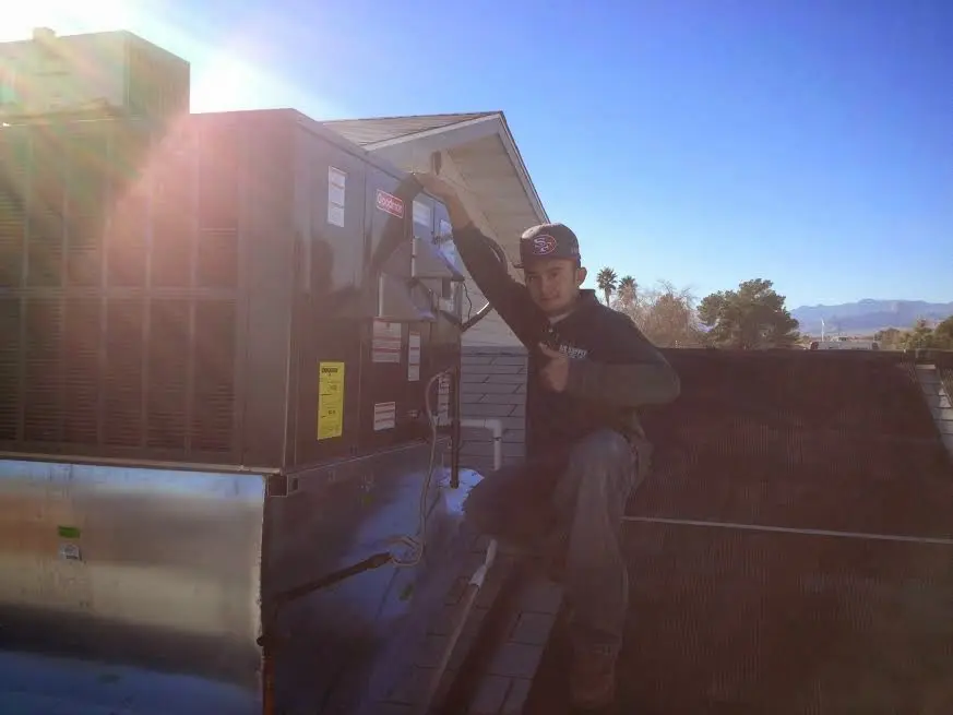 HVAC technician performing Boiler Repair on a rooftop unit in Kenmore